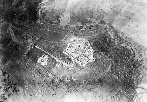Fig. 2 : Photographie aérienne oblique de 1938, prise du Nord-Est : l’Acropole est entièrement dégagée, alors que dans la Ville Haute ne sont fouillées que la rue sud et une église